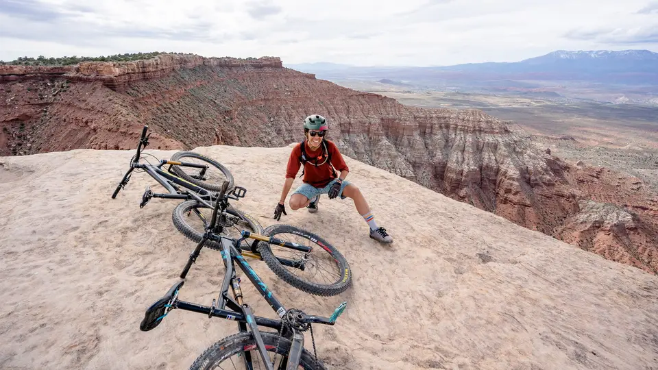 Melanny sitting at the edge of Gooseberry Point with her bike in Hurricane, Utah