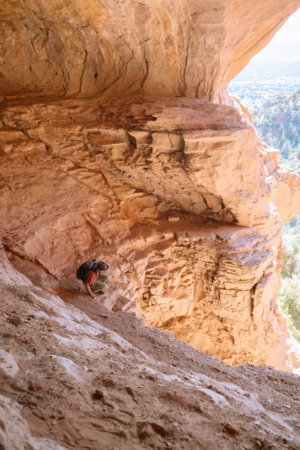 Evan crouching on the sloped floor under the Keyhole Cave overhang