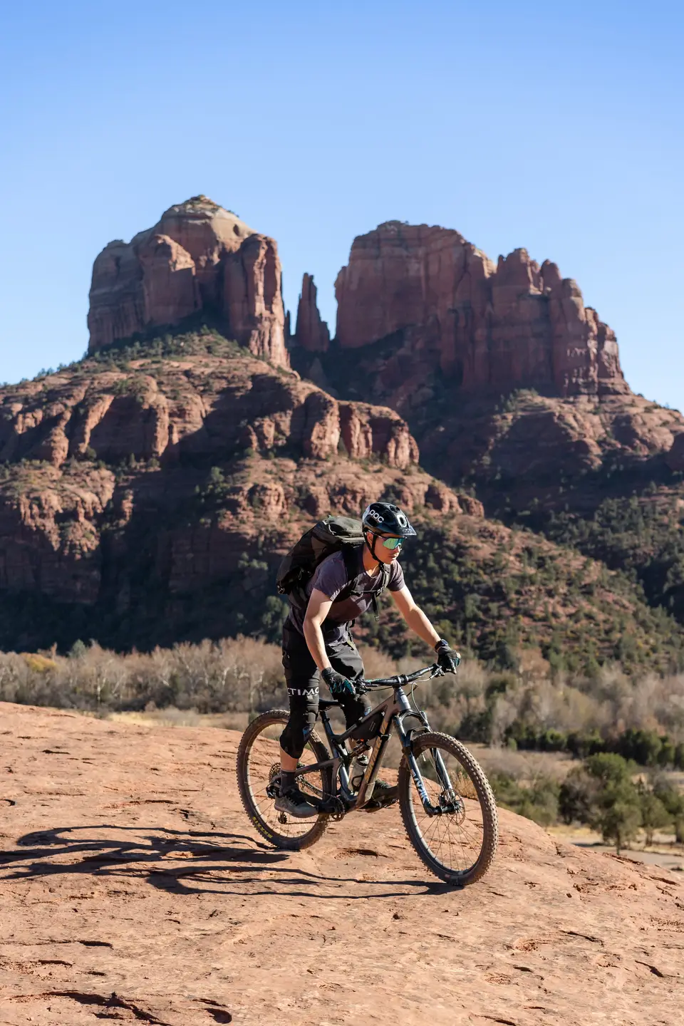 Evan riding past Cathedral Rock on the secret slickrock trail in Sedona, Arizona