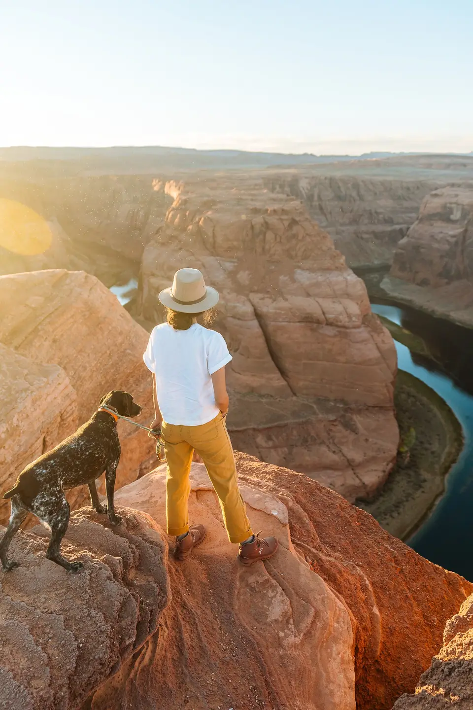 Melanny and Penelope on a rock above Horseshoe Bend in low sun