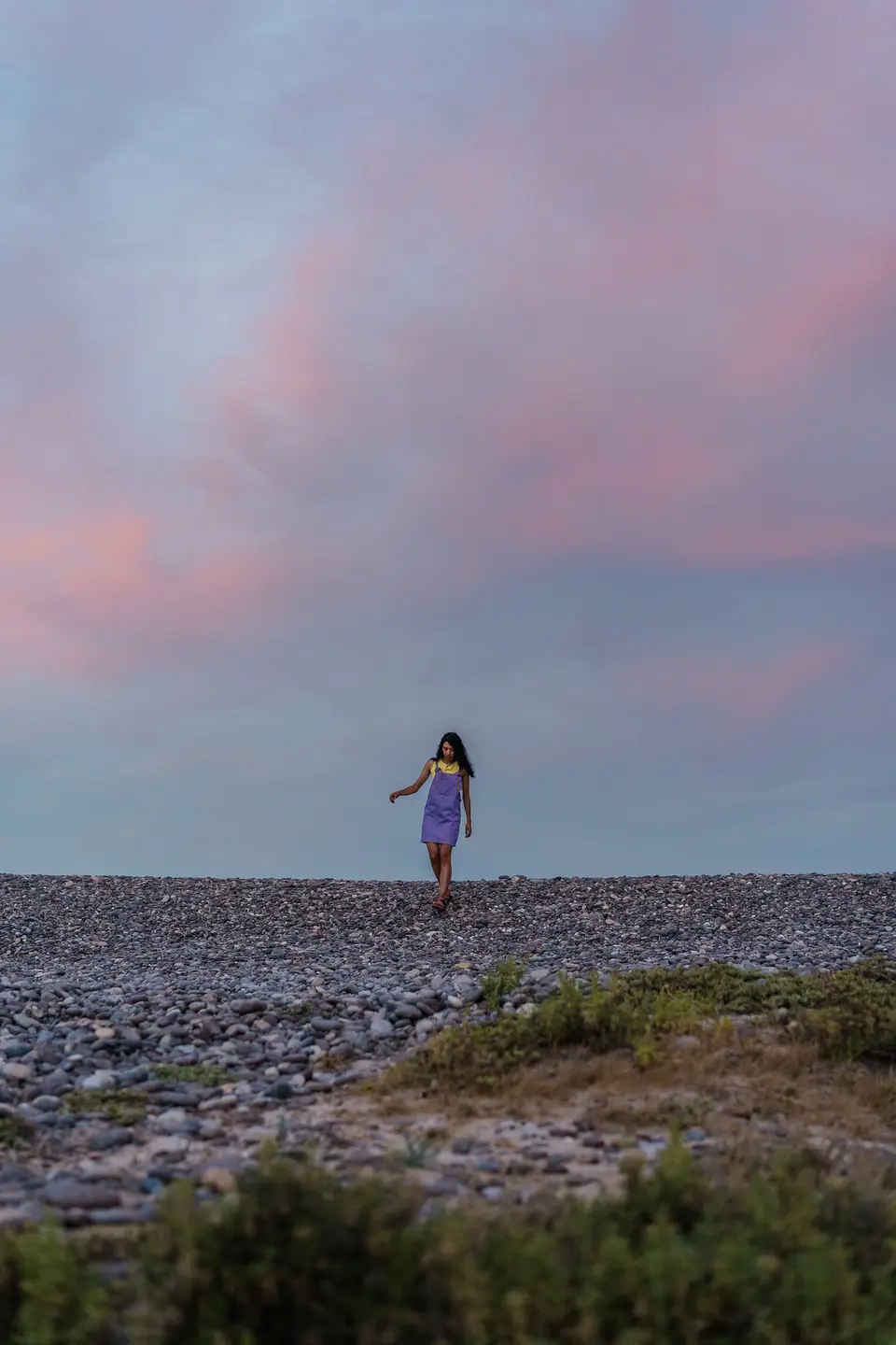 A silhouetted figure on a rocky shore against a pink sunset at Cabo Pulmo, Baja California Sur