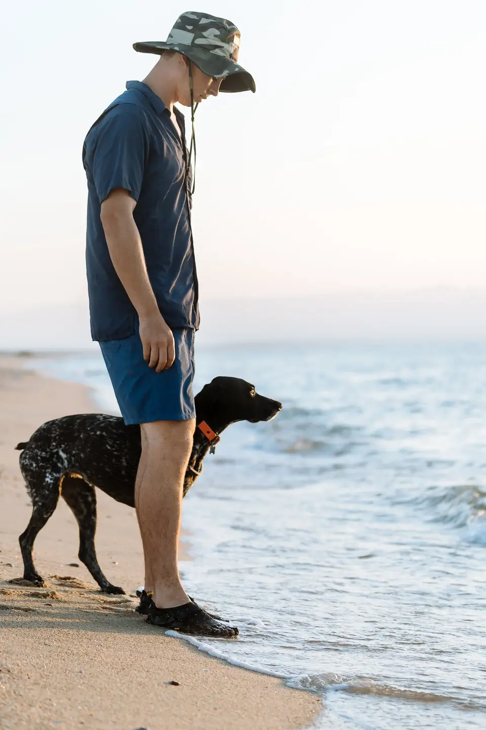 Evan and Penelope on a sandy beach looking toward the surf at La Ventana, Baja California Sur