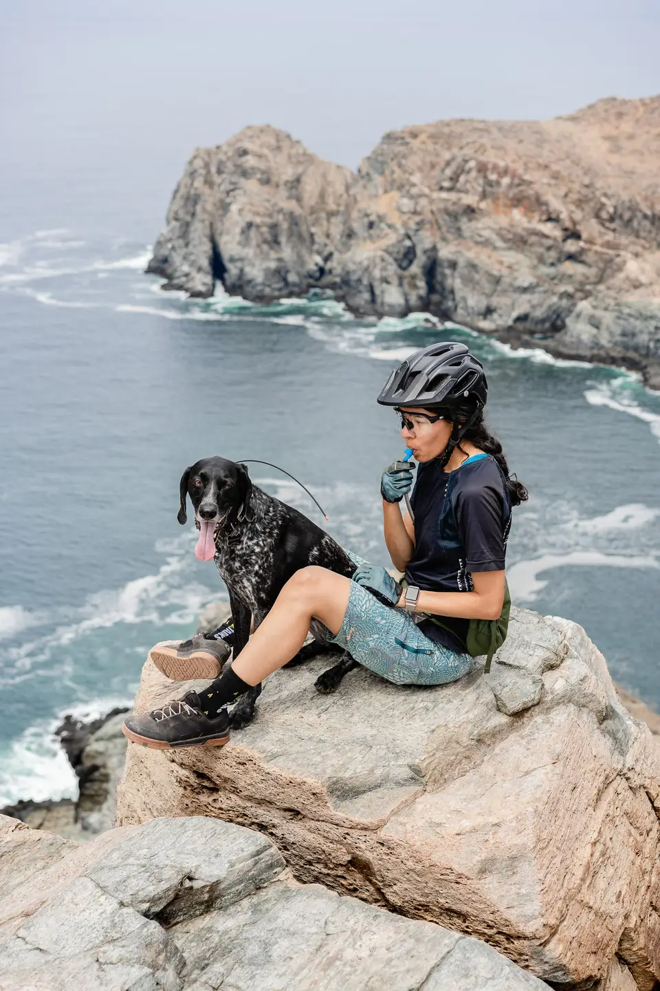 Melanny and Penelope sitting on a cliff above the surf near Todos Santos, Baja California Sur