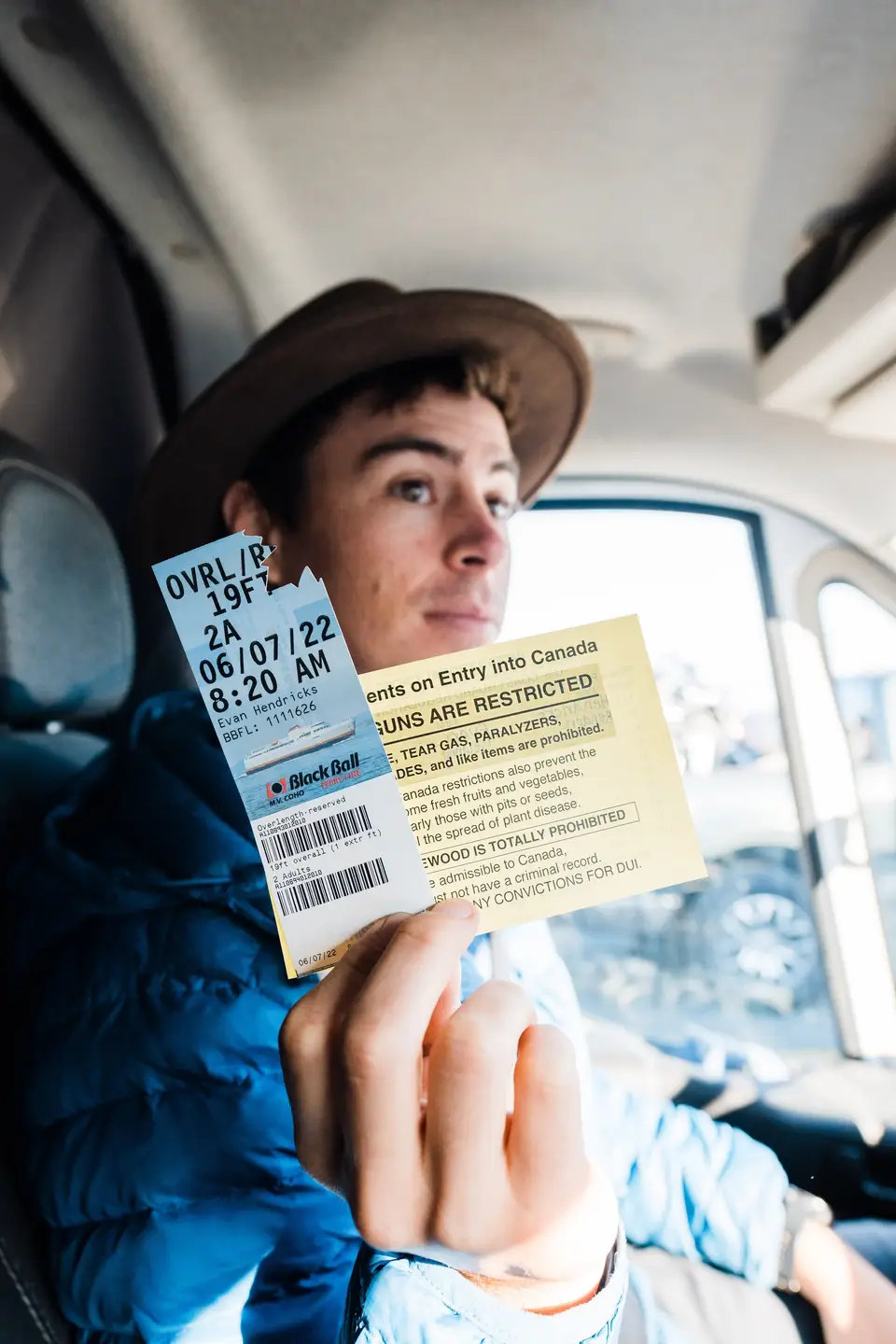 Evan holding a Black Ball ferry ticket and a Canada entry sheet