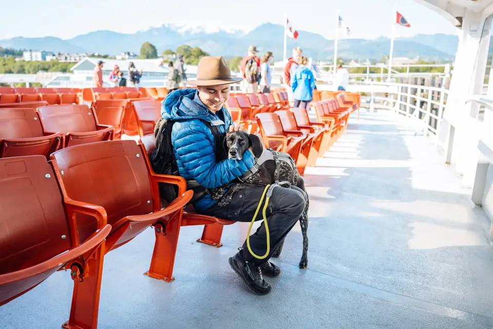 Evan hugging Penelope on the orange Coho ferry seats