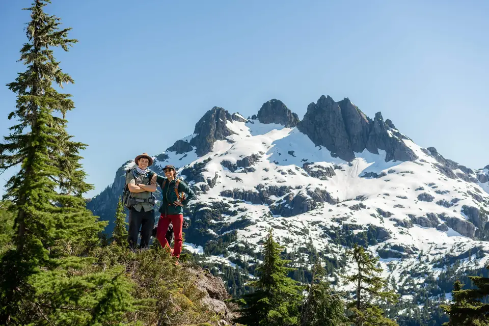 Evan and Melanny on a ridge below a snow peak near Tofino