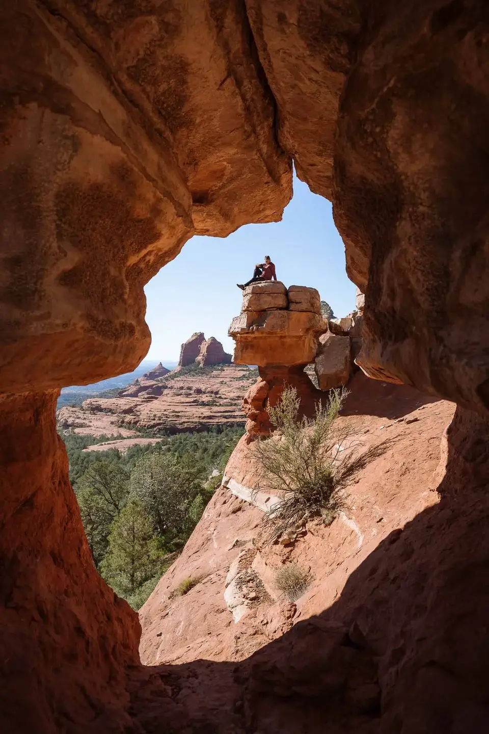 Looking out of Merry-Go-Round cave at Evan sitting on the rock stack