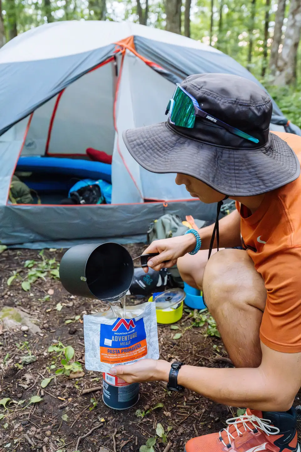 Pouring hot water into a freeze-dried meal beside a tent on Blood Mountain, Georgia