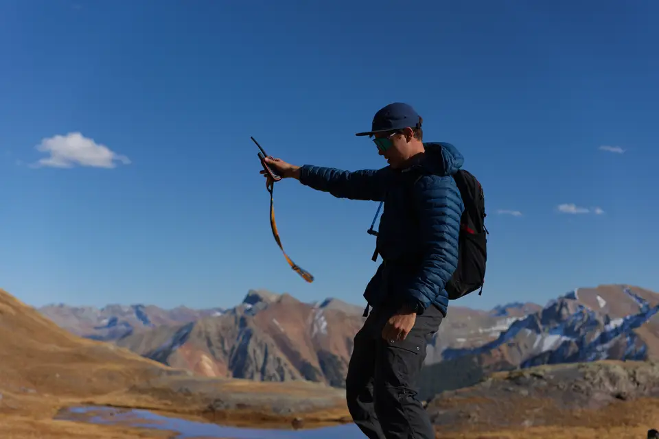 On the trail above Silverton, Colorado, with a daypack and the San Juan Mountains behind