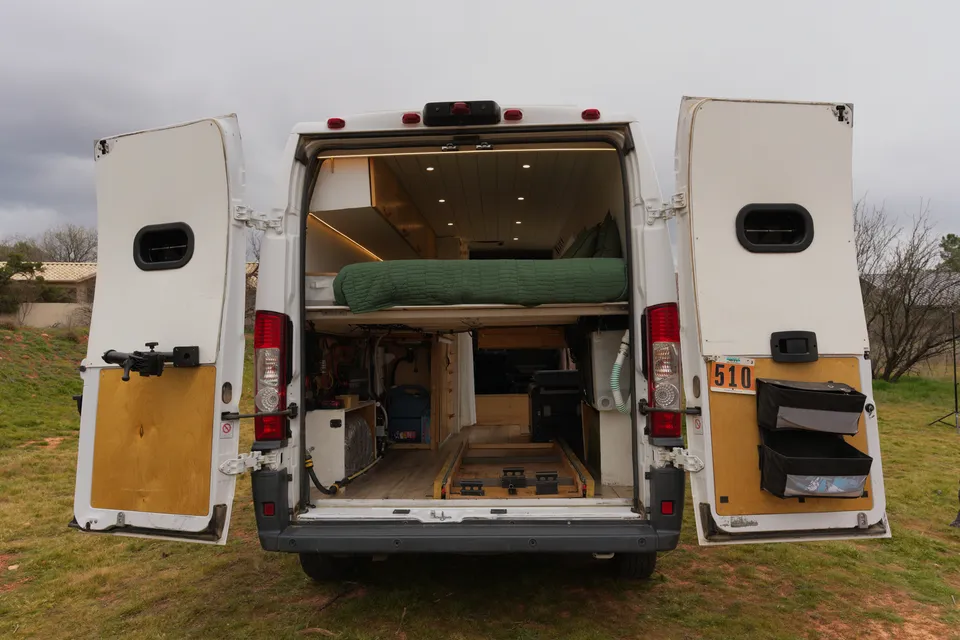 Rear doors of our Promaster open to show the raised bed, garage storage and drawers