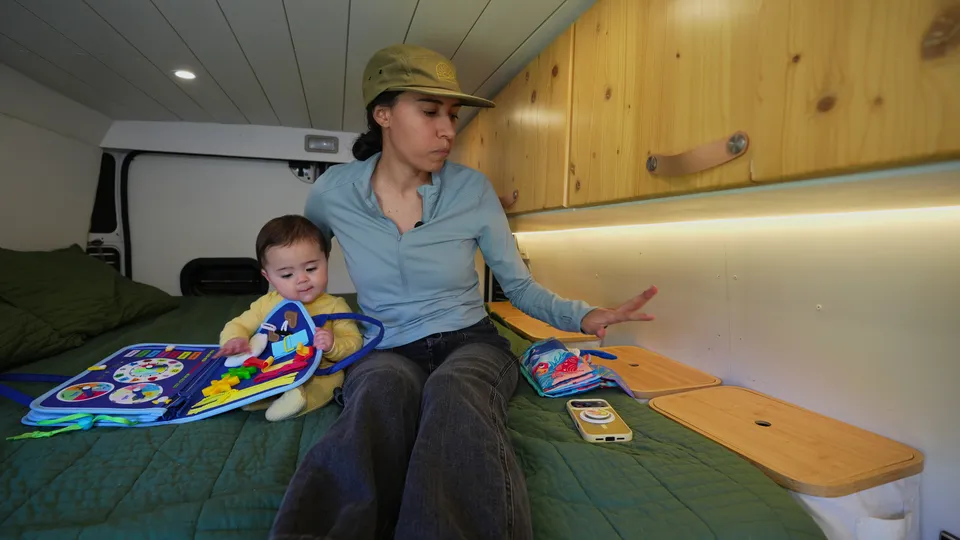 Melanny sitting on the van bed with Mia and her books