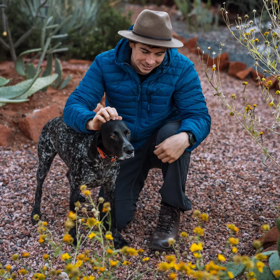Evan kneeling with Penelope in a desert garden