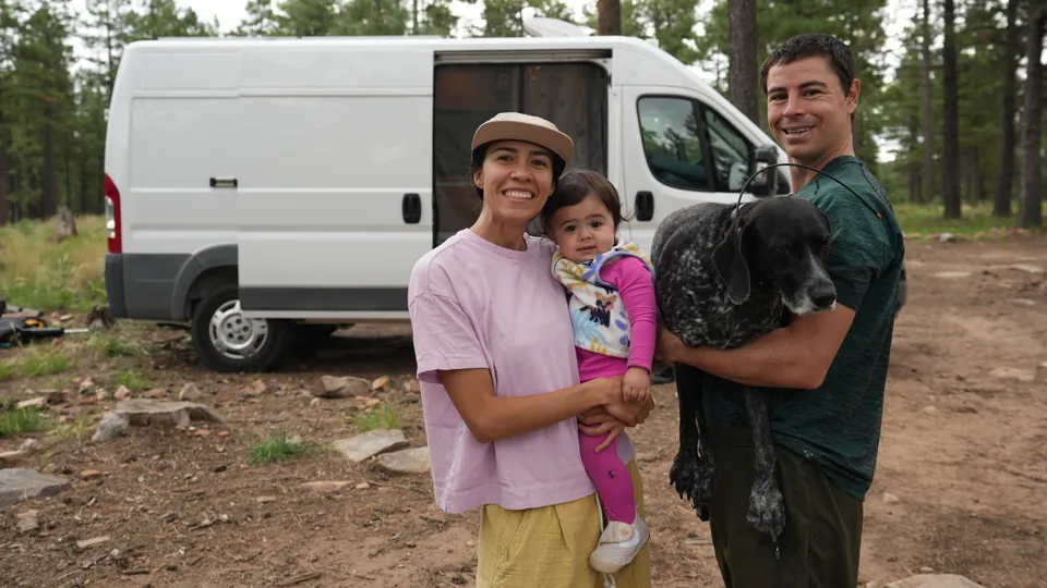 Evan, Melanny, their baby and their dog in front of the Promaster van in the pines near Payson, Arizona